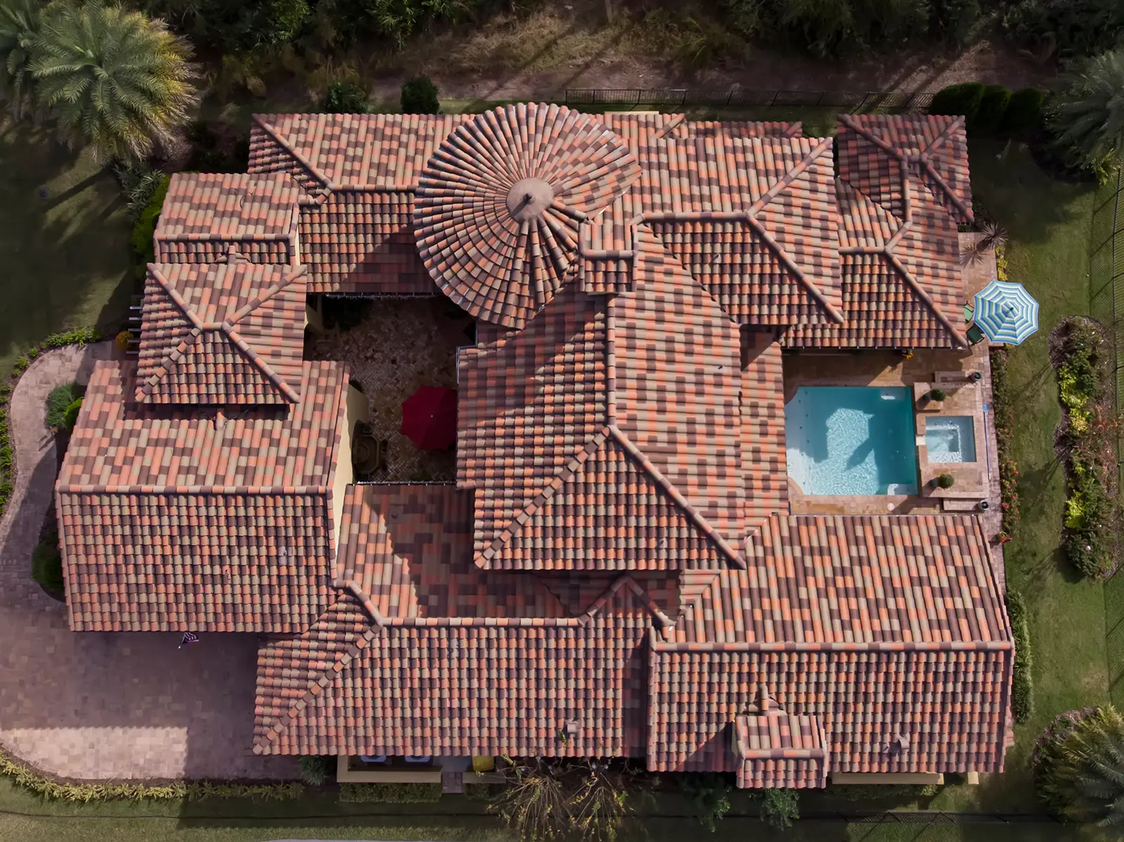 Aerial view of a new multi-color barrel tile roof on a Jacksonville home with a courtyard pool