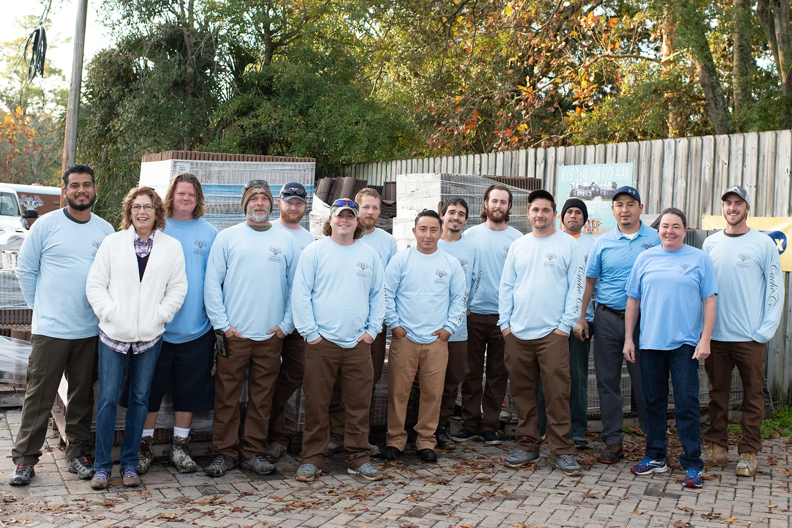 The Cache Roofing team standing in front of pallets of roofing tile at the company yard in Jacksonville, Florida