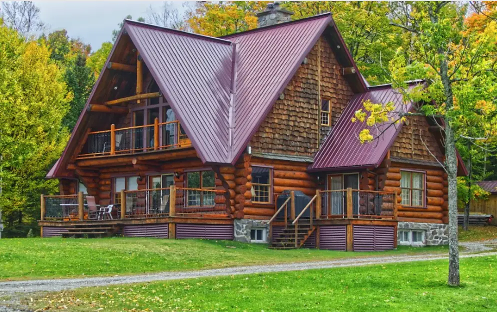 Log home with a red standing seam metal roof