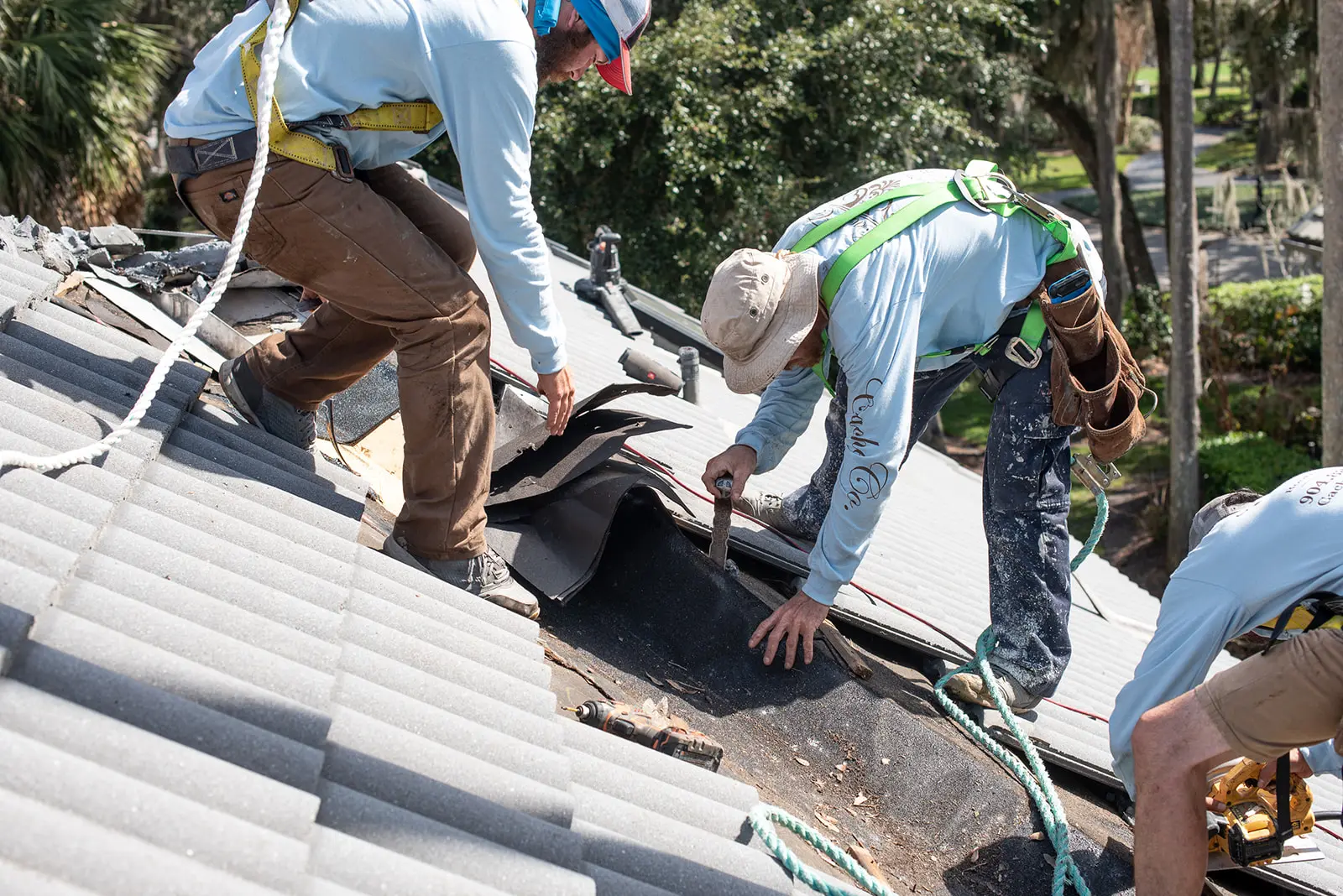 Cache Roofing crew installing underlayment on a concrete tile roof