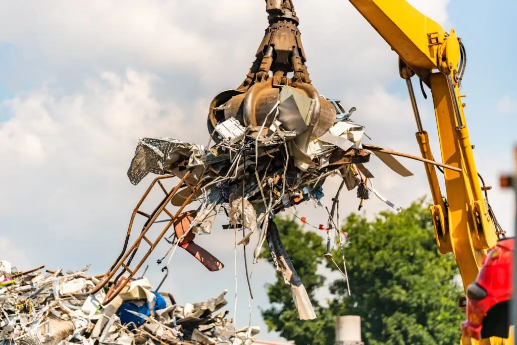 Crane grabbing scrap metal for recycling