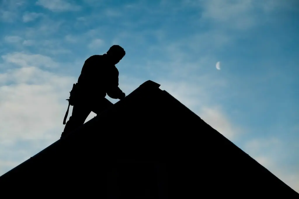 Contractor in silhouette working on a rooftop